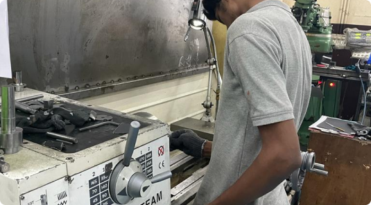 Technician operating a lathe machine