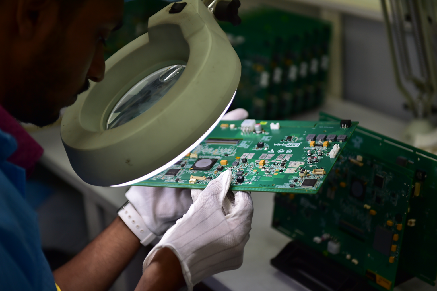 Technician handling printed circuit boards at ELCIA Tech Hub