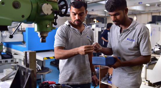 Engineers inspecting a machined component on the shop floor